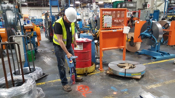 Voyez un employé entrain de scanner la dalle pour trouver les armatures dans le béton.